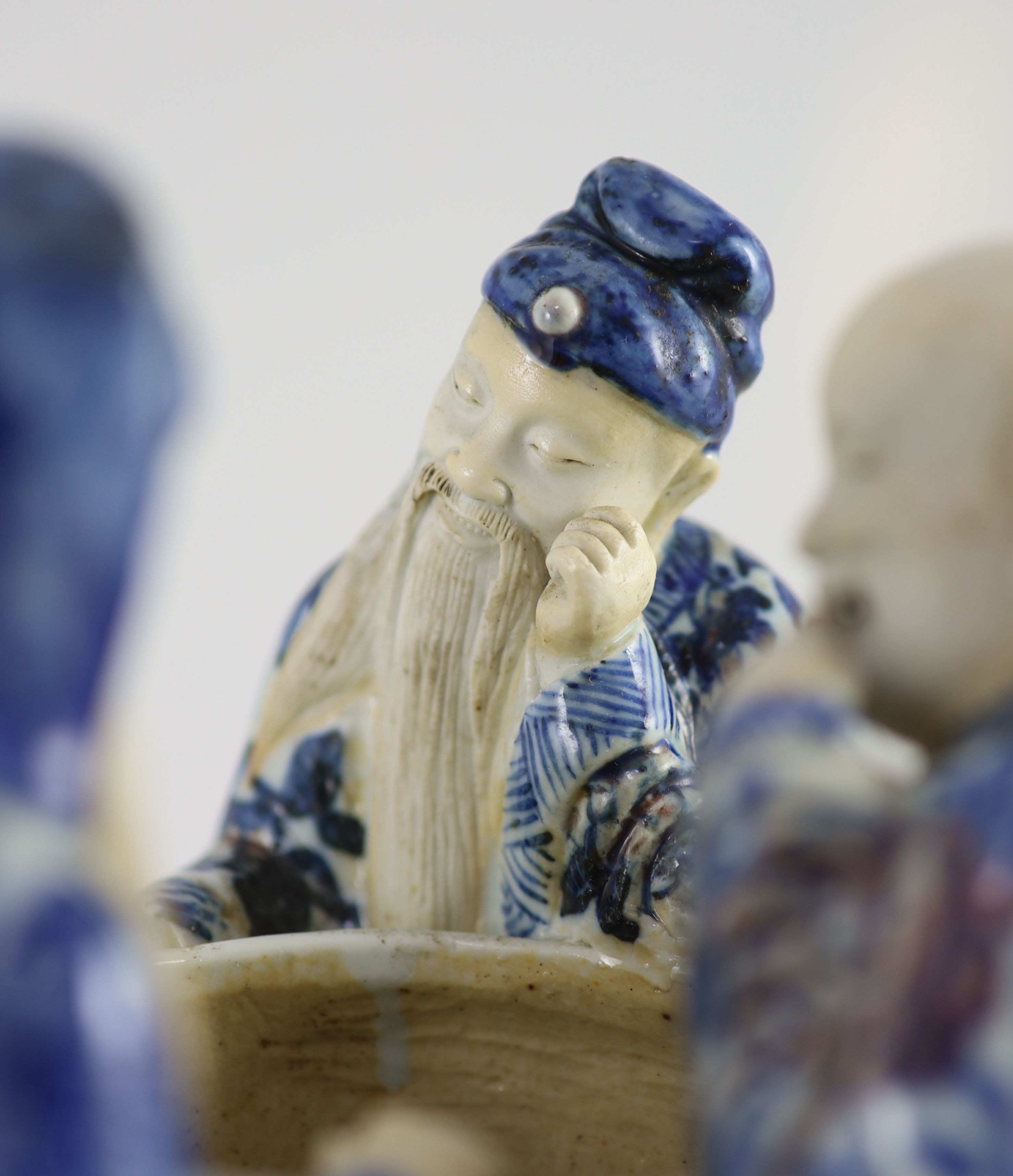 A rare Chinese underglaze blue and copper red porcelain model of the ‘Vinegar Tasters’, Qing dynasty, 26.cm high